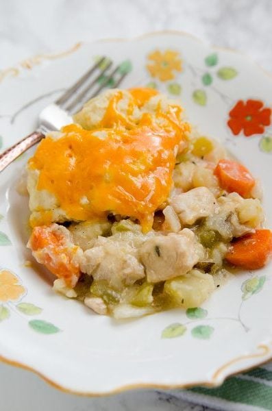 Chicken stew with steamed biscuits and melted cheddar cheese on top.