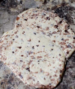 Two cinnamon buns that are raw, placed together and rolled together to make one cinnamon bun flatbread.