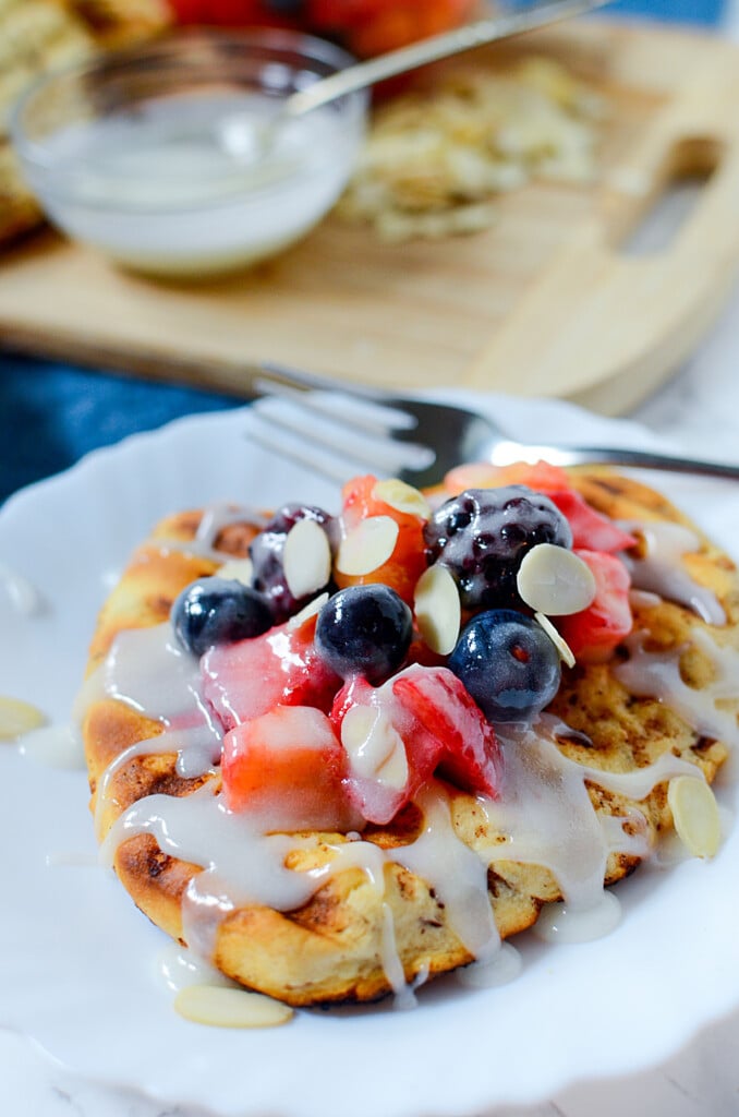 A grilled cinnamon roll flatbread with fruity topping and glaze on top. 