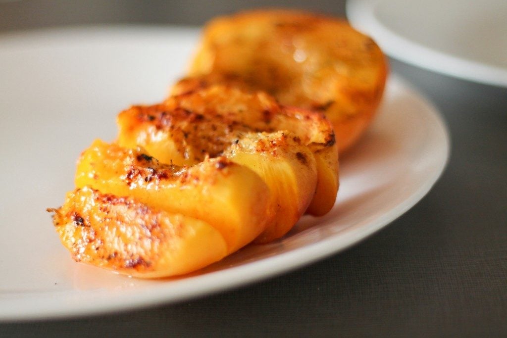 Grilled peaches on a plate.