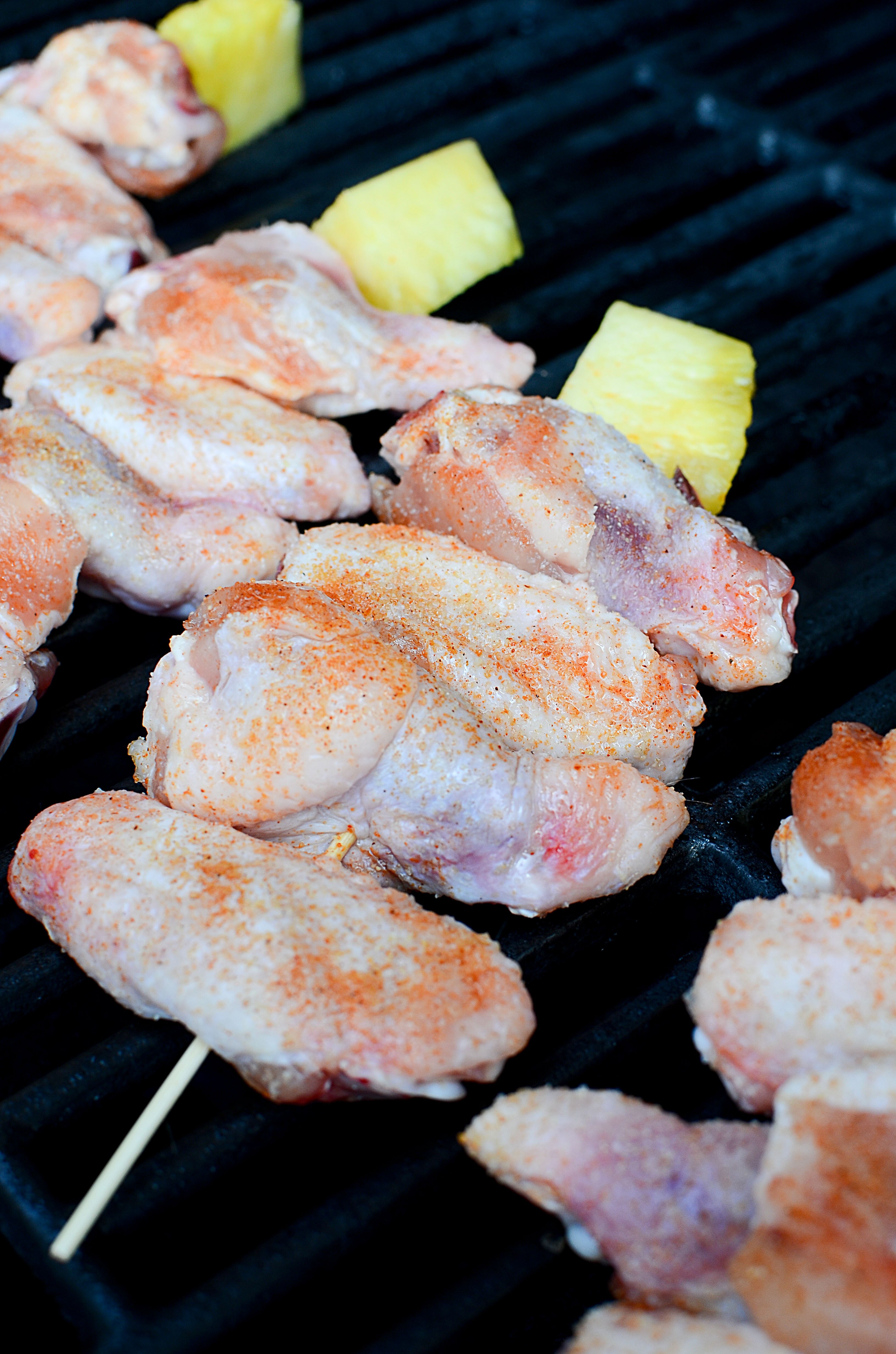 The raw skewered wngs on the grill.