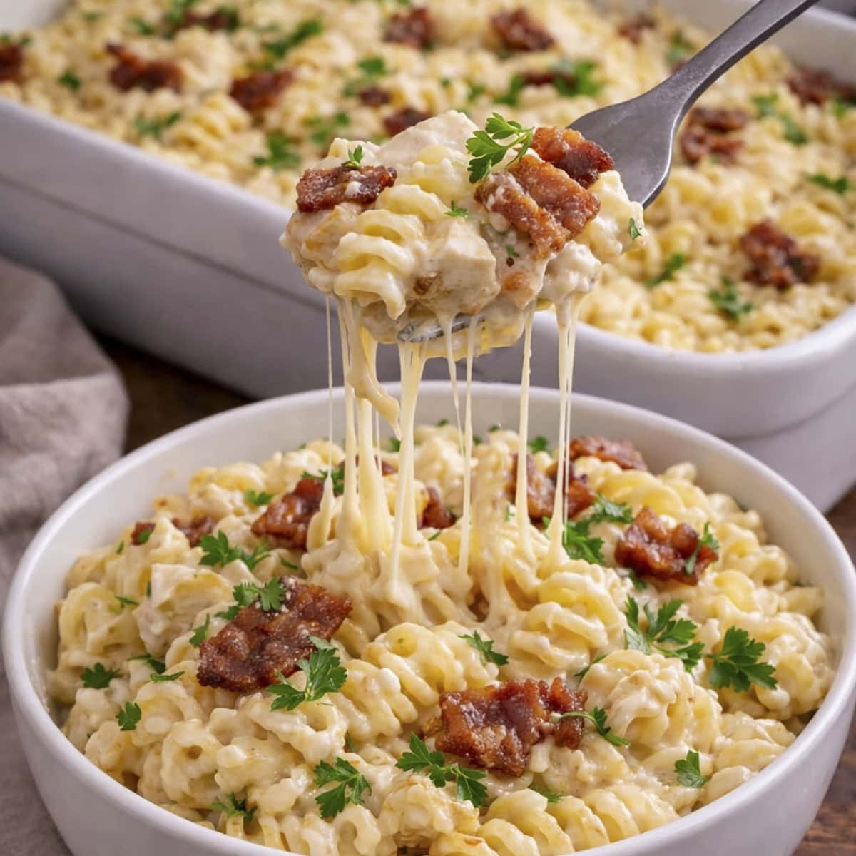 A bowl of chicken fusilli pasta bake with a fork in it.