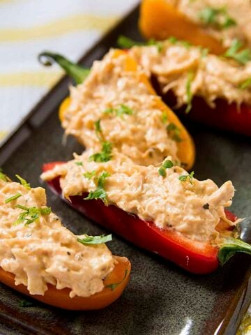 A stuffed mini pepper with buffalo chicken dip on a black plate.