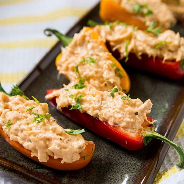 A stuffed mini pepper with buffalo chicken dip on a black plate.