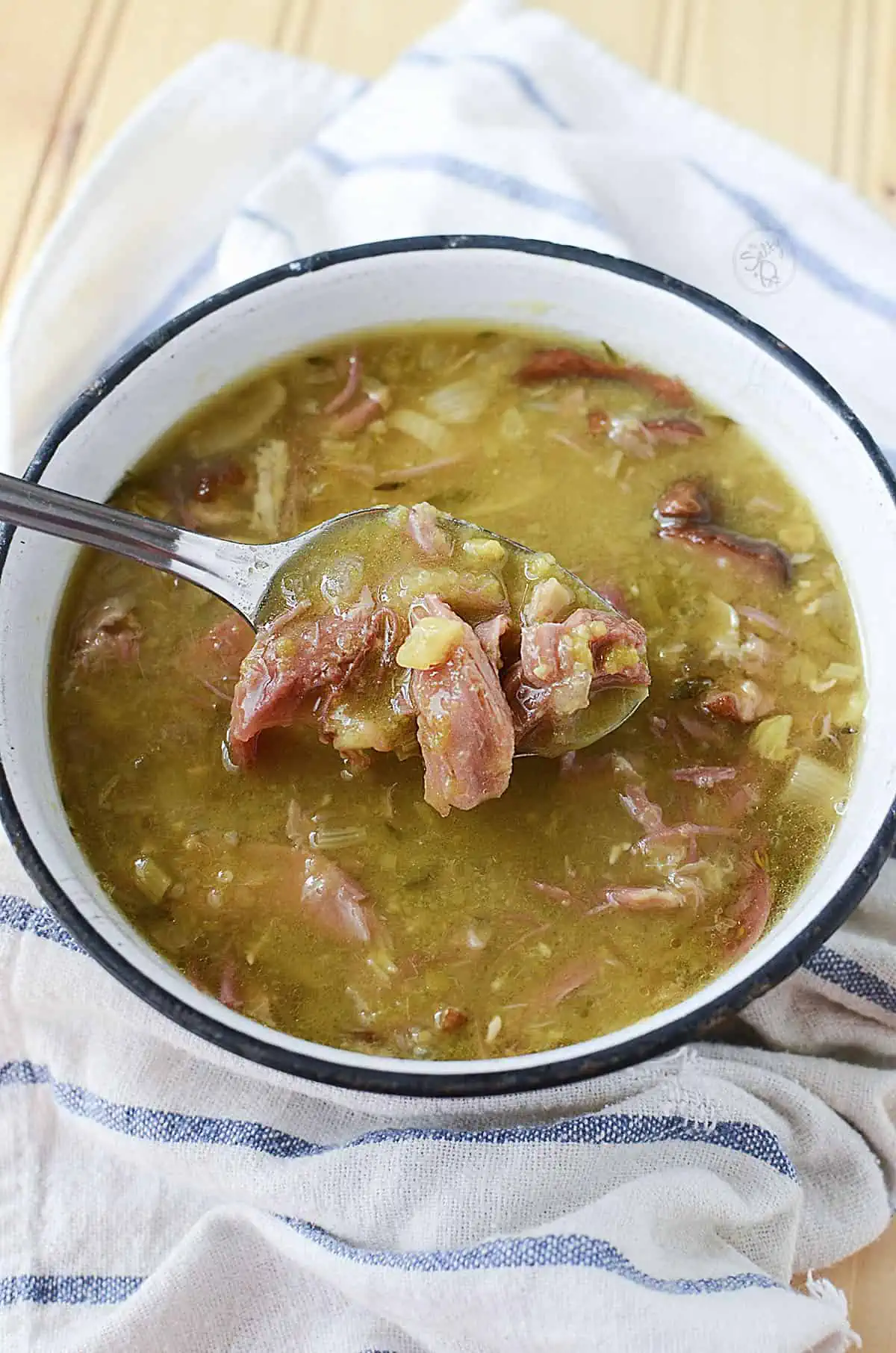 Smoked pork hock soup with a spoon in the bowl.