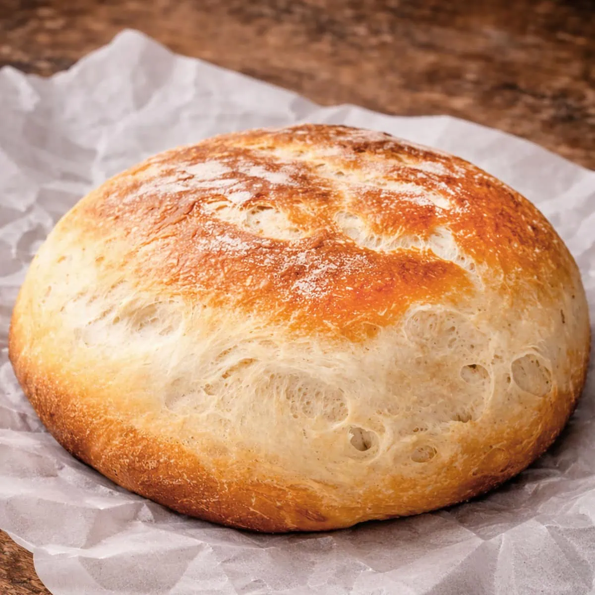 Slow cooker bread on white parchment paper.