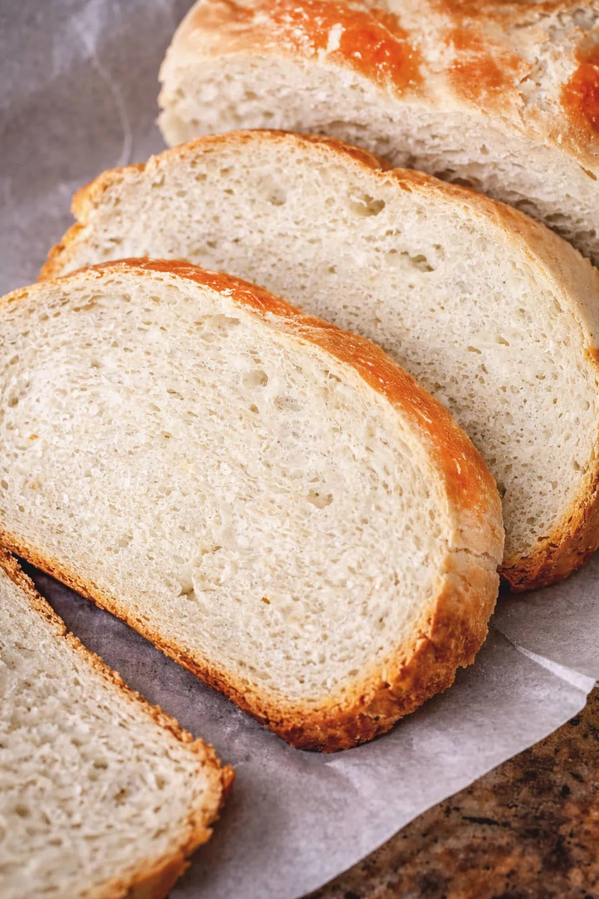 Sliced slow cooker bread on parchment paper.