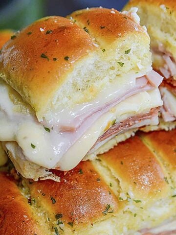 One italian slider resting on top of the other ones in a pan.