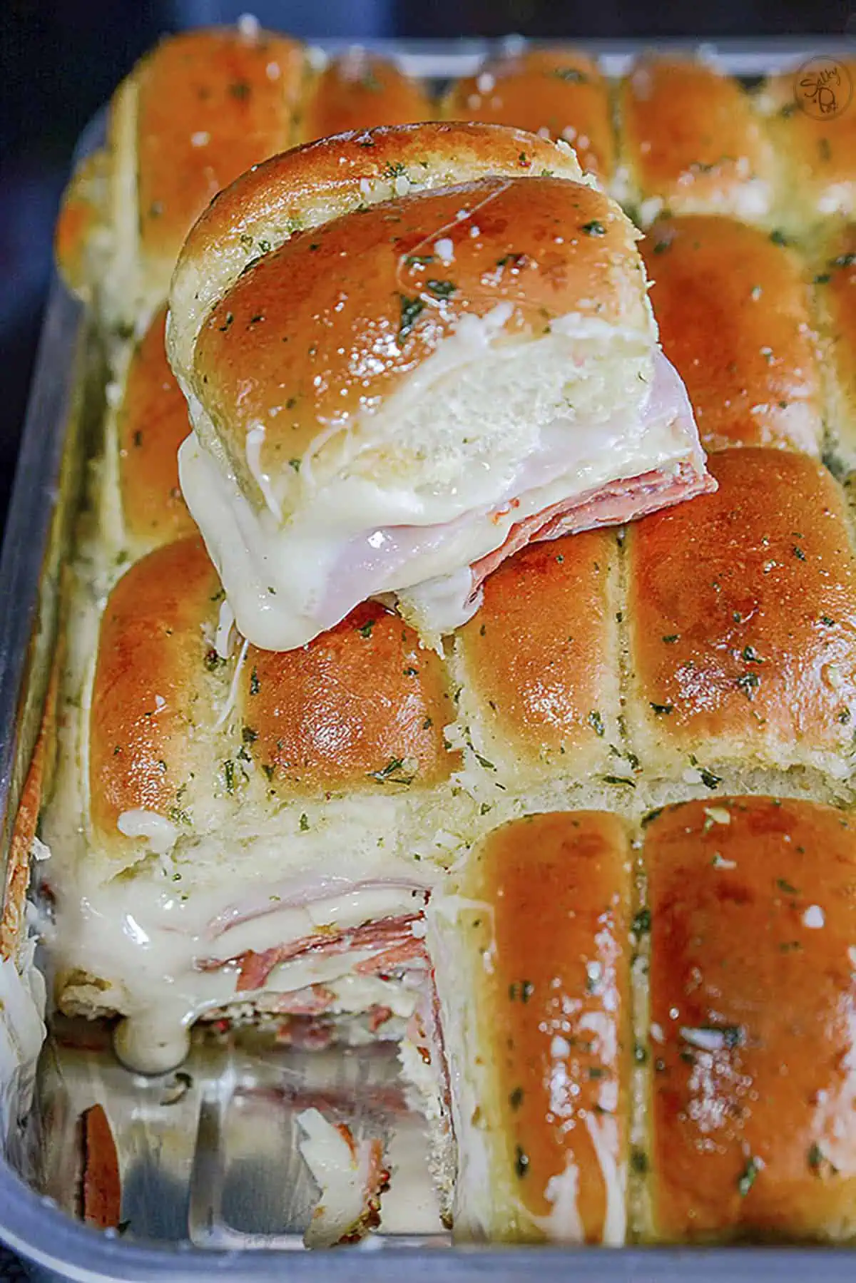 Italian sliders fresh out of the oven in a silver baking pan.