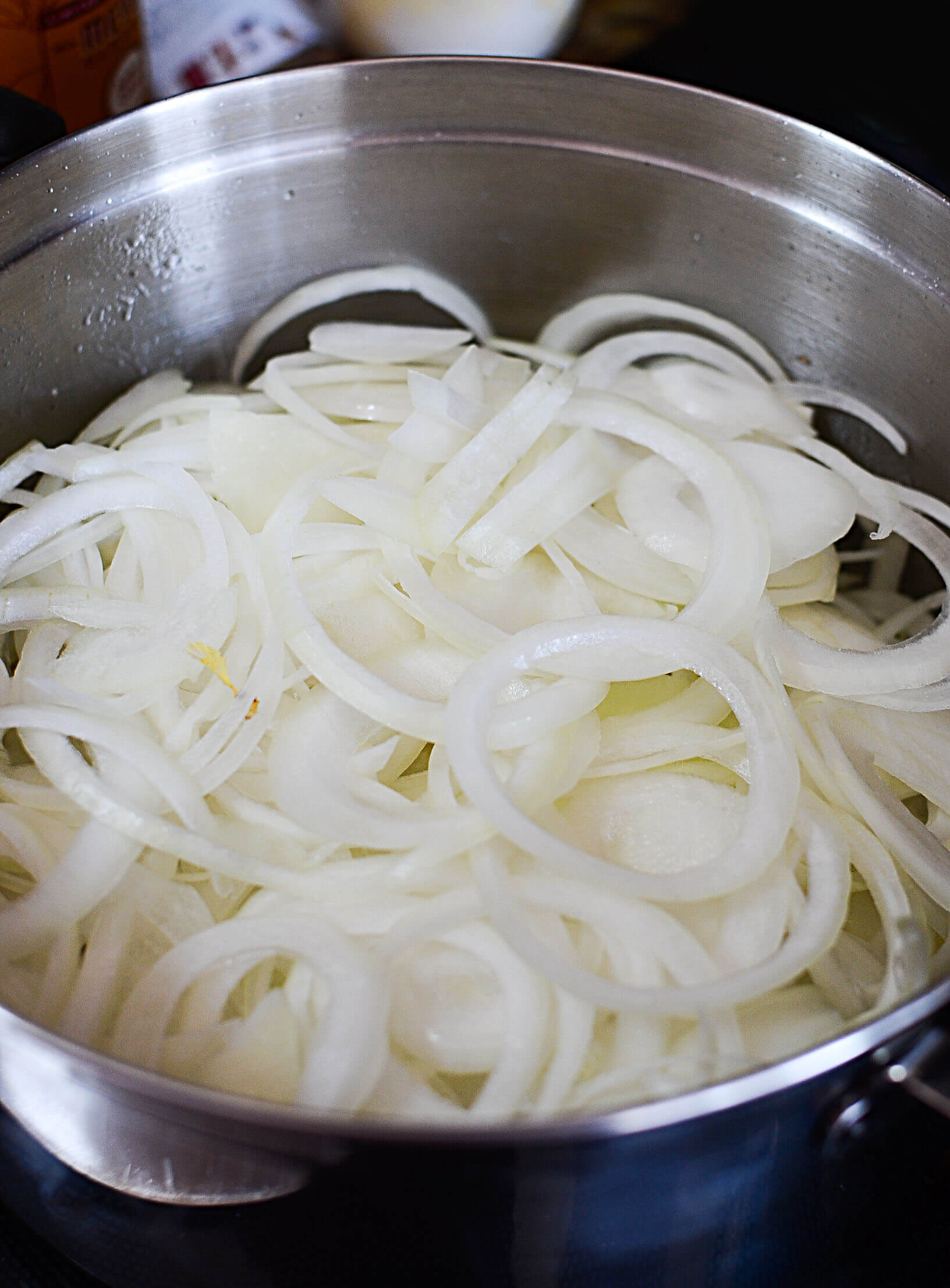 Sliced onions in the pot being sauted. 
