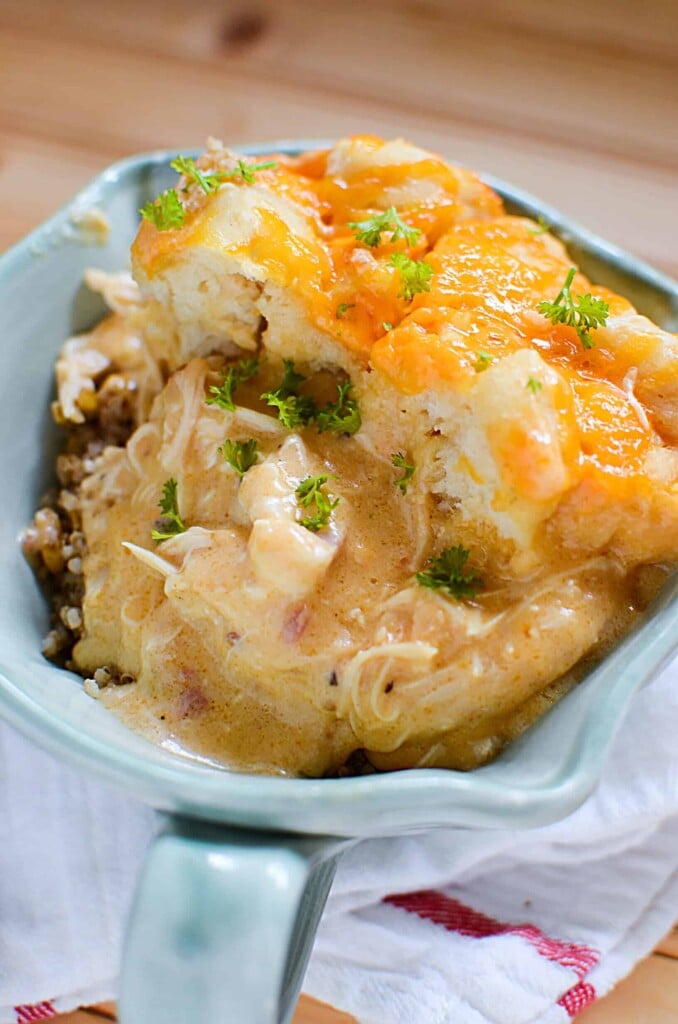 Slow cooker comfort food at it's finest! Slow cooker cheesy chicken and biscuits has creamy cheese sauce, juicy chicken topped with soft biscuits, all done in the slow cooker! This crock pot cheesy chicken and biscuits dish will be one in your regular rotation - it's so easy, using ingredients right from your pantry!