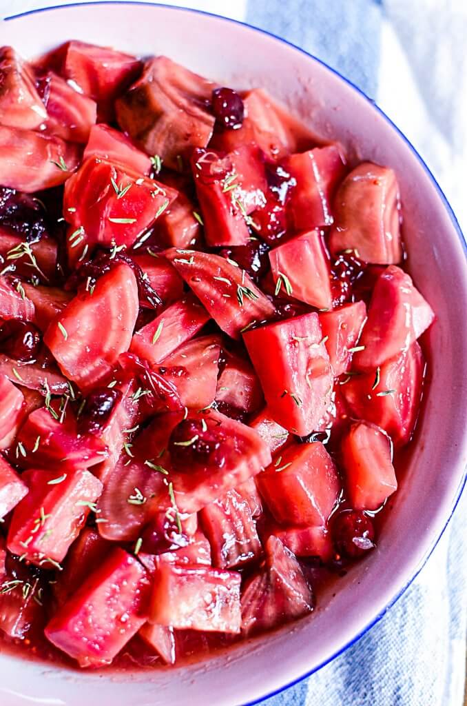 Pretty candy cane beets jeweled with ruby cranberries, sweetened with honey and orange! This recipe is perfect for children and new beet eaters! Sweet and tart, these slow cooker beets please the palate PLUS it's super easy to make because it's all done in the crock pot!