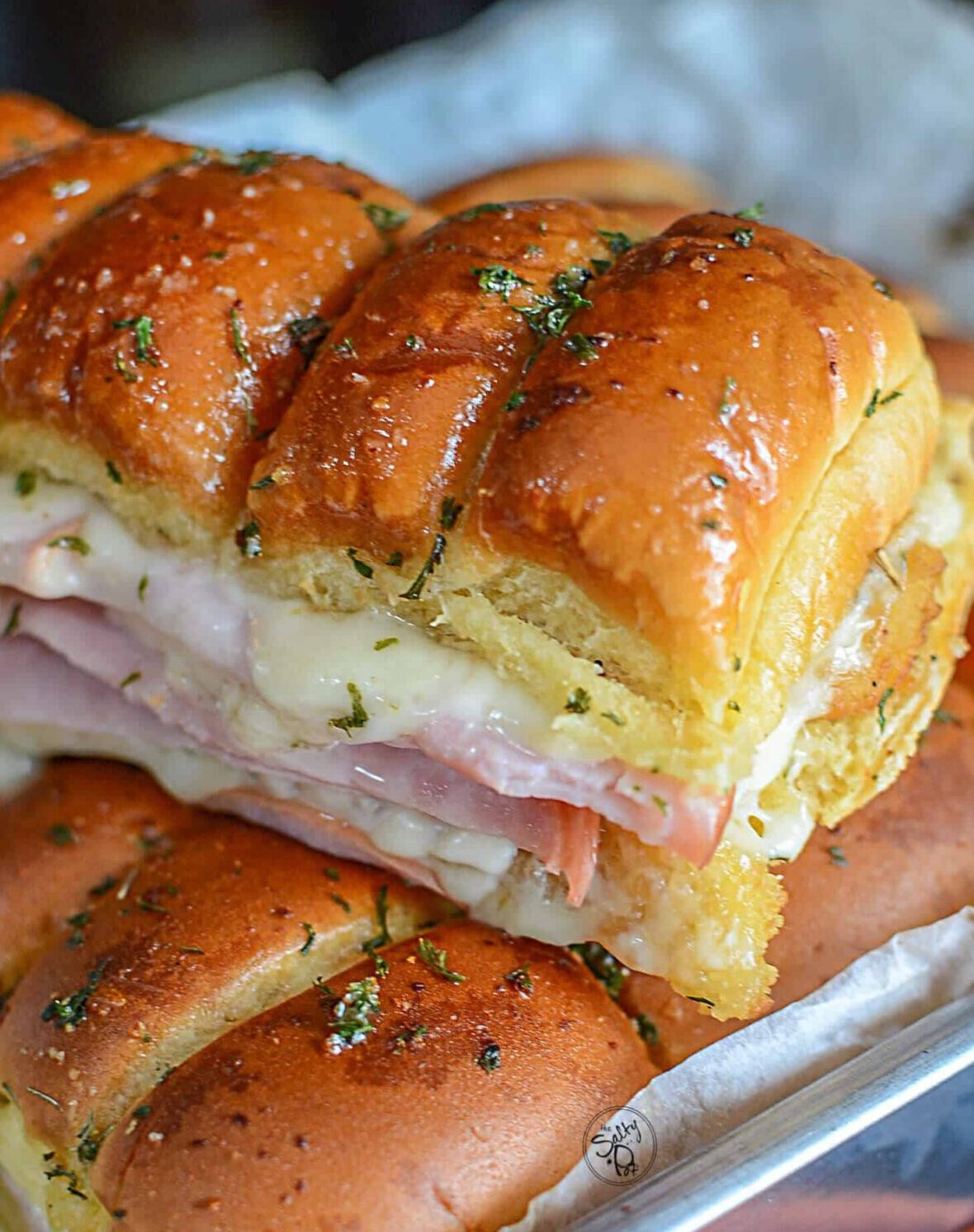 Chicken cordon bleu sliders resting on top of more sliders, fresh from the oven.