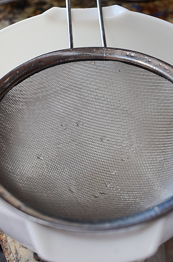 A clean strainer over a white bowl.