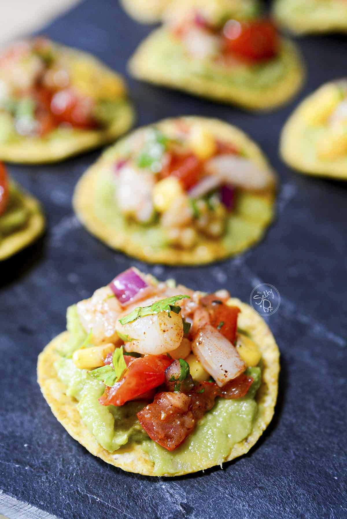 A bunch of chili lime shrimp appetizers on a blue napkin.
