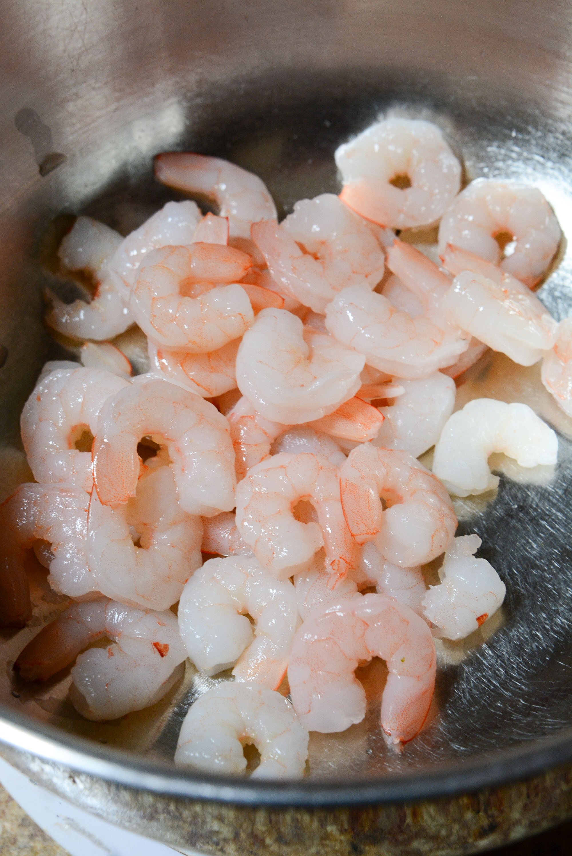 Cooked shrimp in a silver bowl.