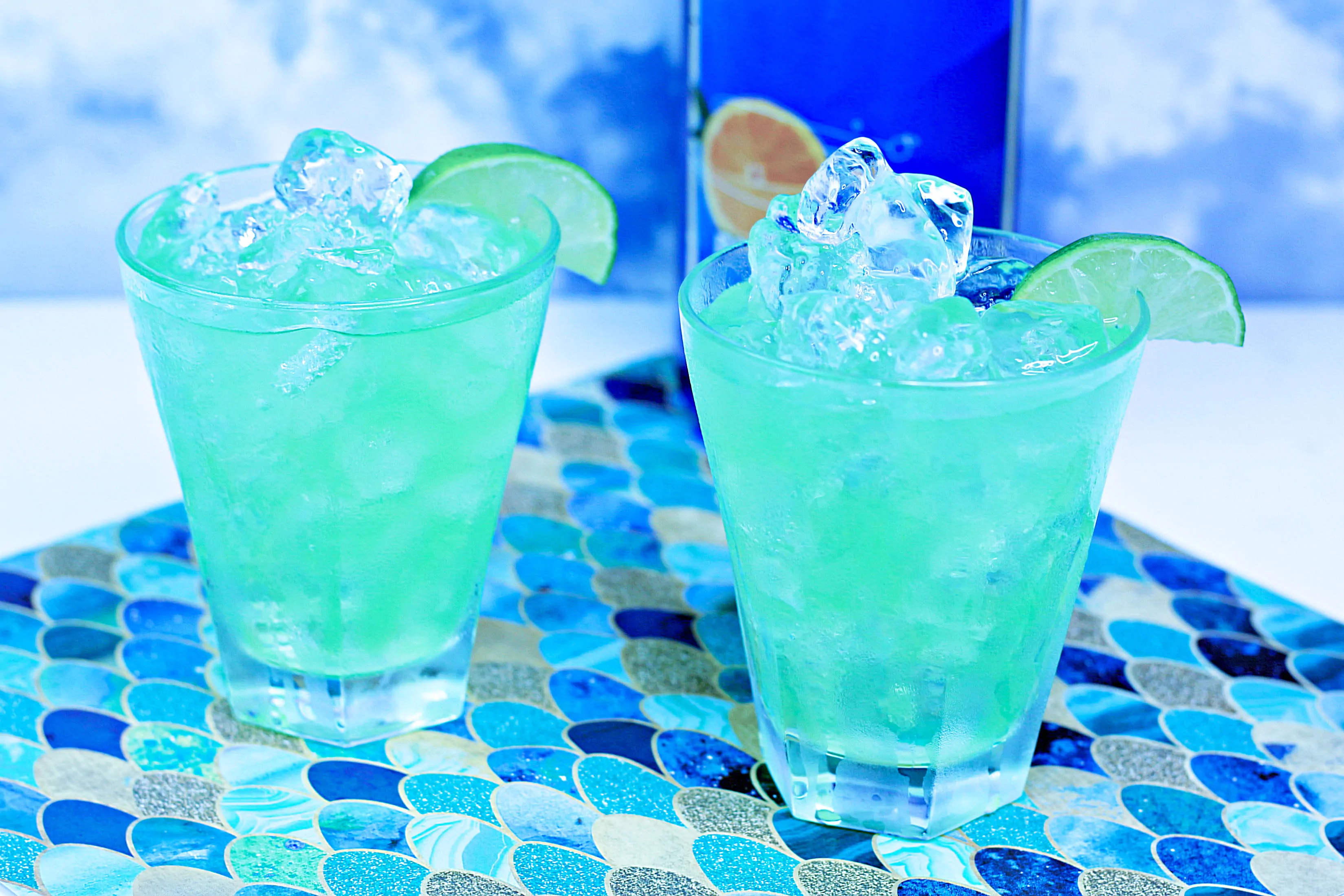 Two glasses with the mermaid drink inside, on a napkin that looks like blue fish scales.