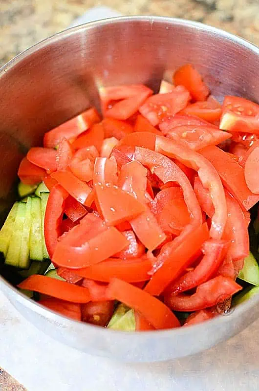 a bowl with cucumbers and tomatoes both sliced