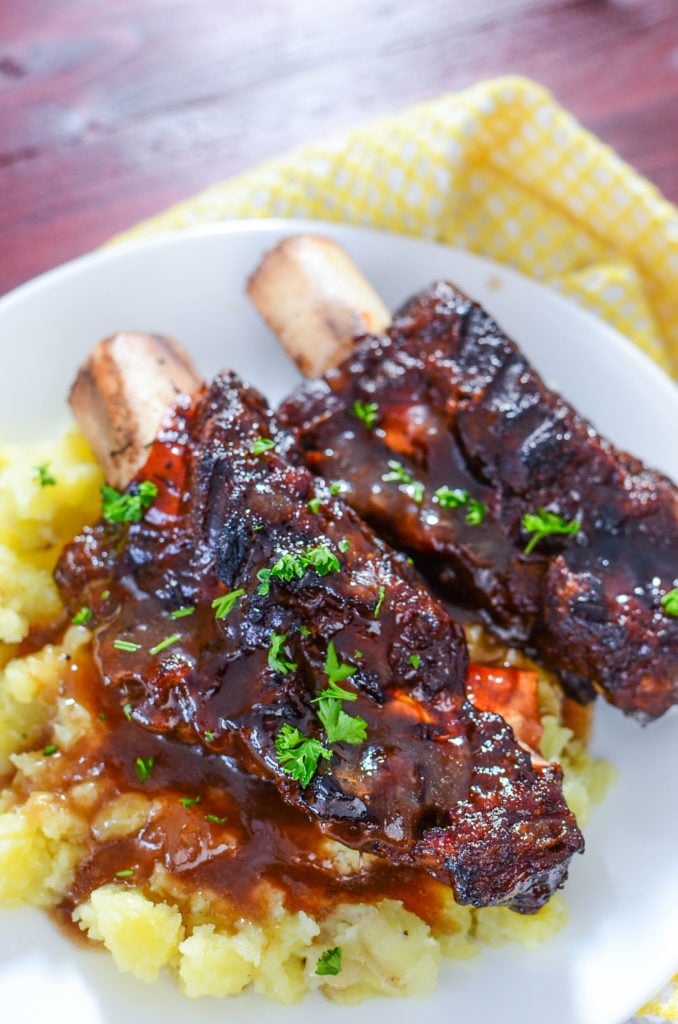 Delicious looking beef short ribs on a white plate with mashed potatoes