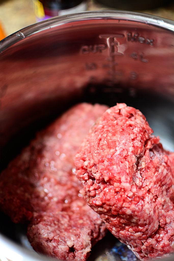 2 pounds of frozen raw ground beef inside the instant pot cooking pot