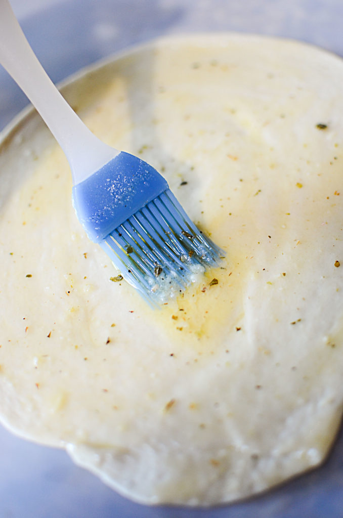 Garlic butter seasoned with italian seasoning brushed on the dough.