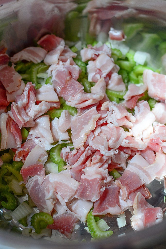 Raw bacon with celery and onions in the instant pot insert, ready to saute