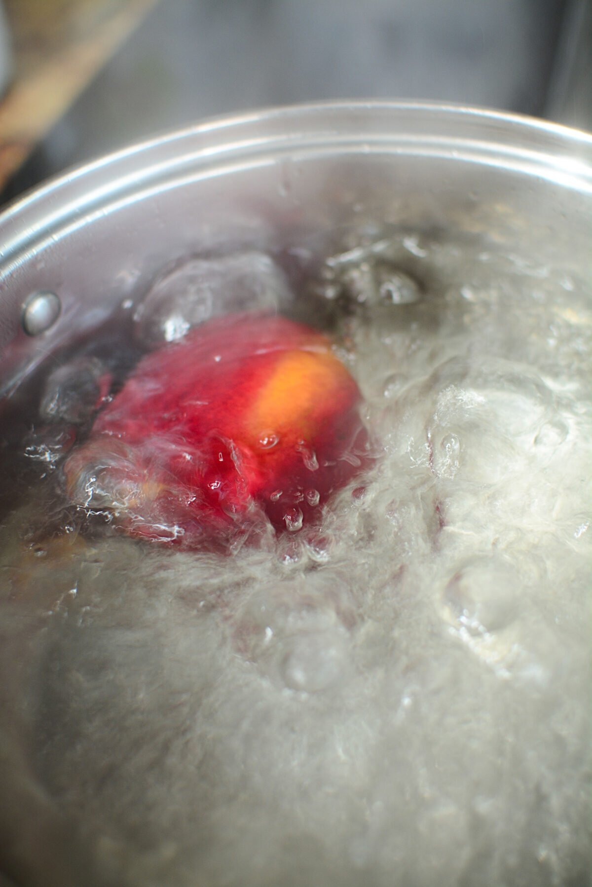 A peach submerged in boiling water.