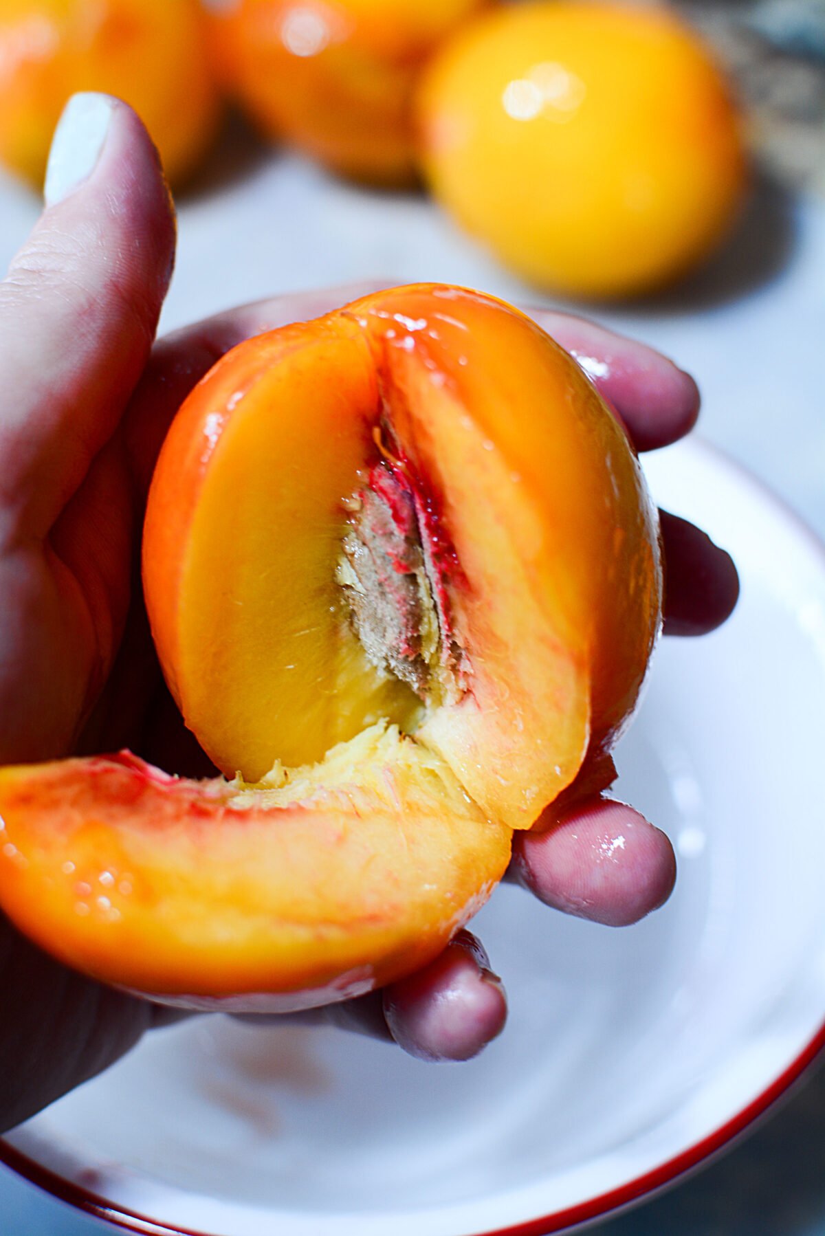 A peach being sliced into sections.