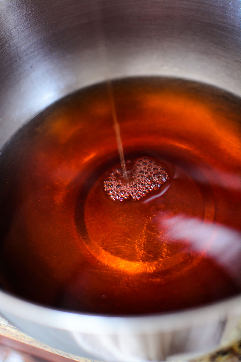 Cinnamon flavored syrup in a silver bowl.