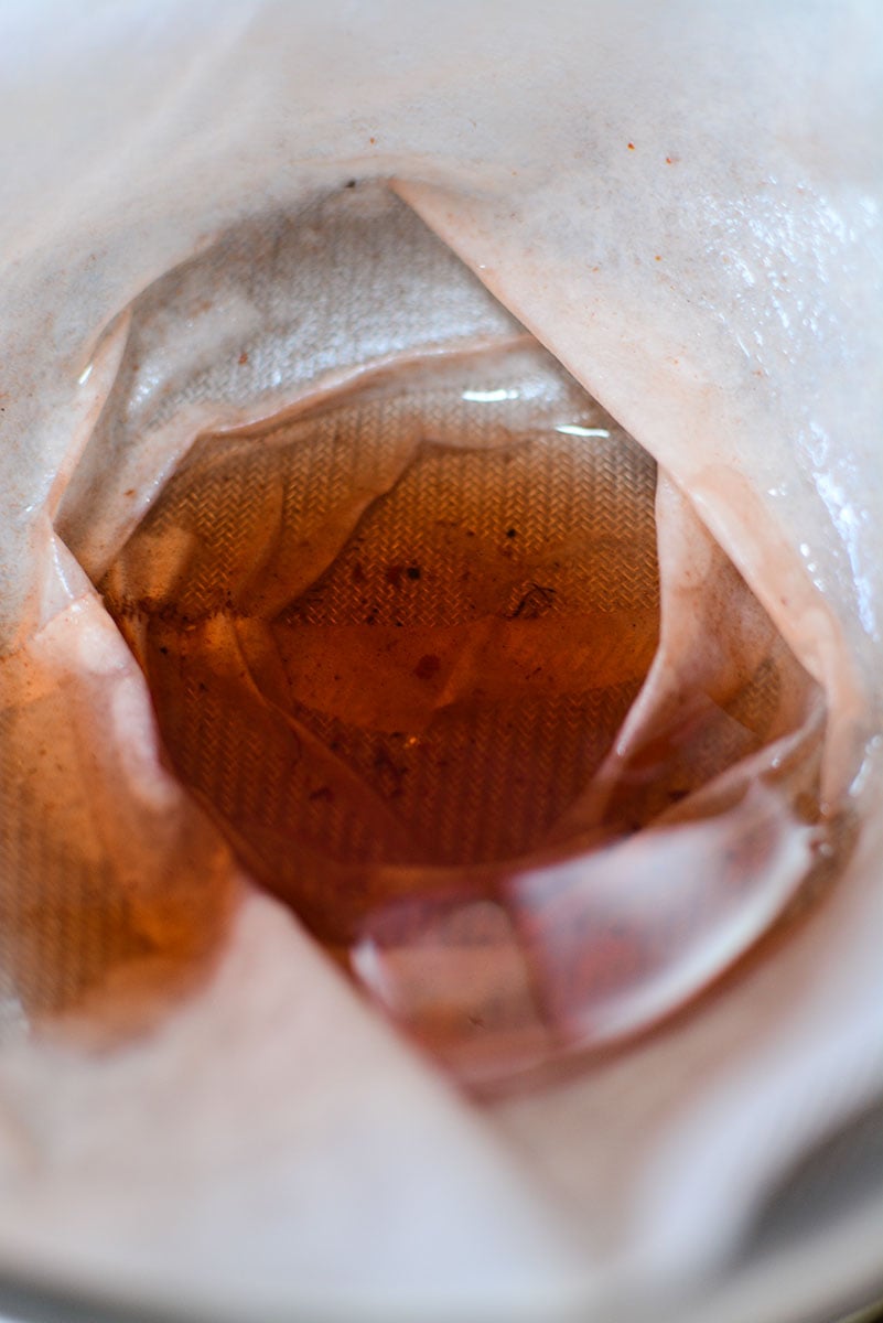 Cinnamon infused sugar water straining through a coffee filter.