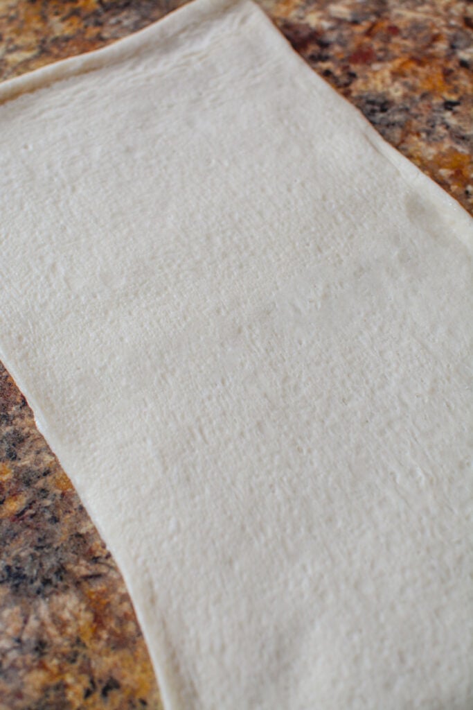 Rolled out pizza dough on the counter.