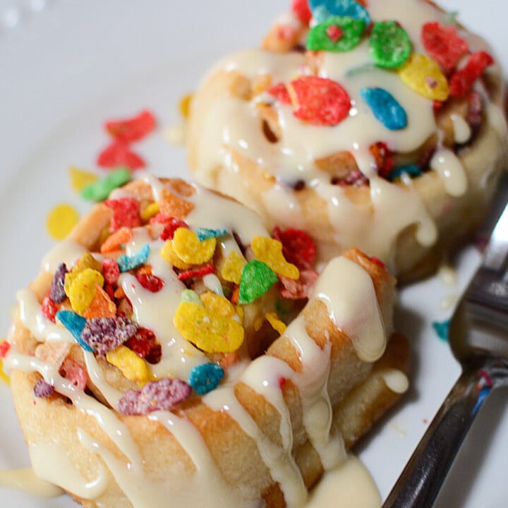 Fruity pebbles sweet rolls on a white plate.