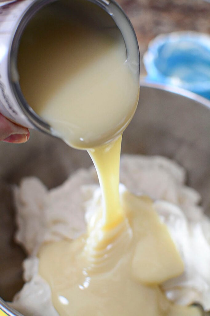 Condensed milk being poured over the yogurt.