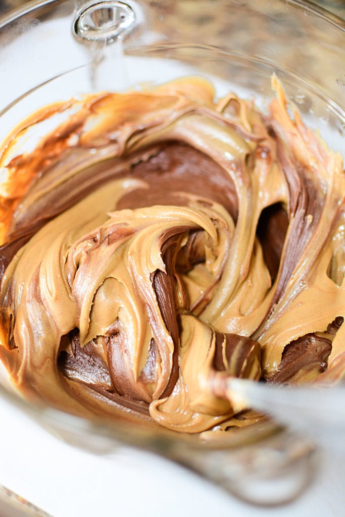 A mixture of some peanut butter and chocolate frosting in a bowl