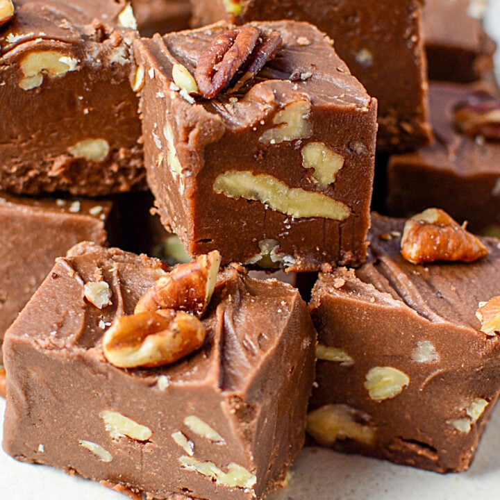 2 Ingredient fudge piled on a white plate with a blue napkin in the top right corner.