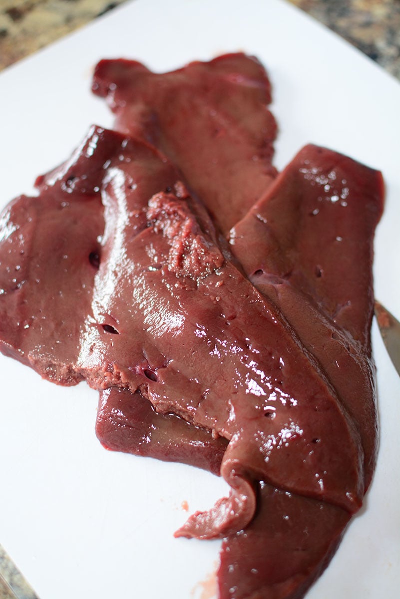 An image of fresh beef liver sitting on a white plate