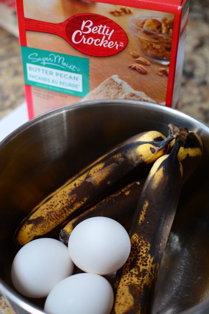 3 Eggs, 3 overripe bananas in a mixing bowl and Berry Crocker cake mix box