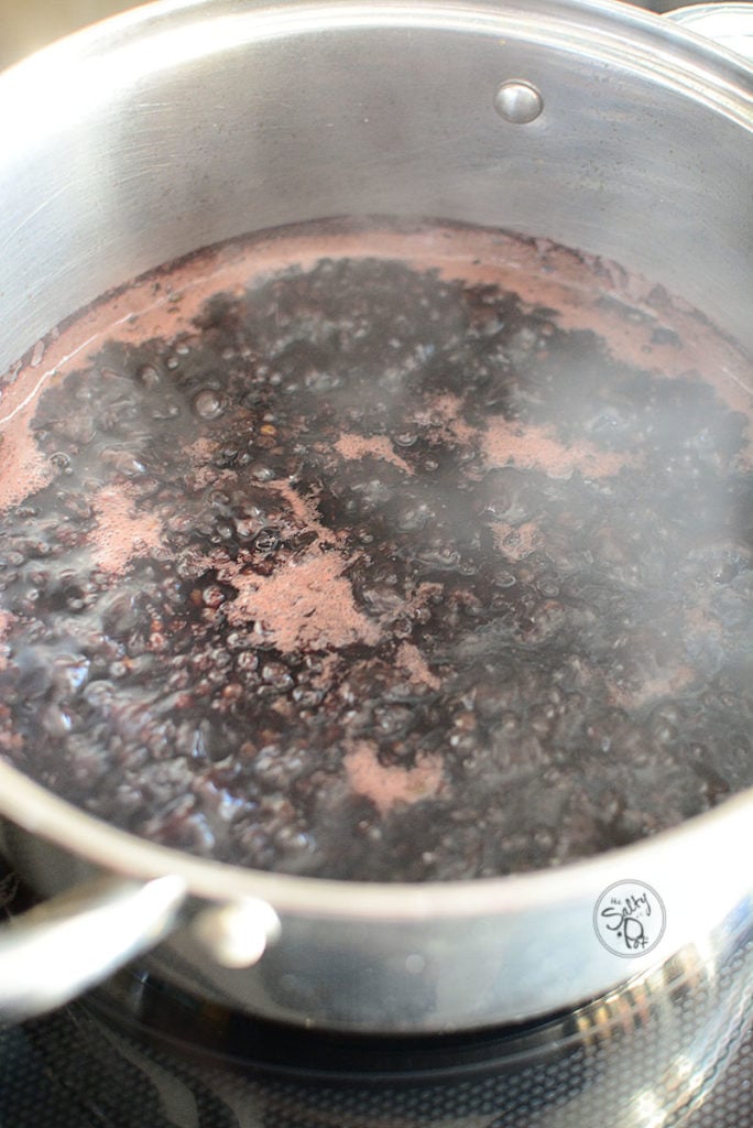 A pot of boiling water with dried elderberries