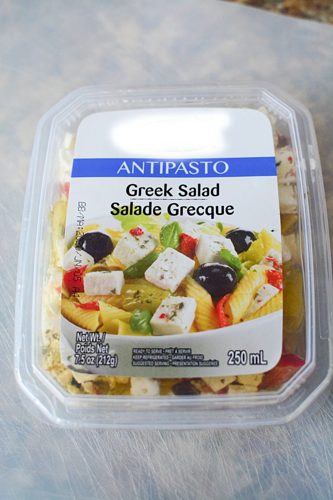 An image of Antipasto Greek Salad in a white plastic container