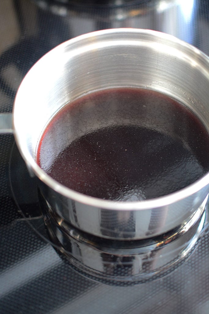 Elderberry gelatin on a stainless pot sitting on a stove