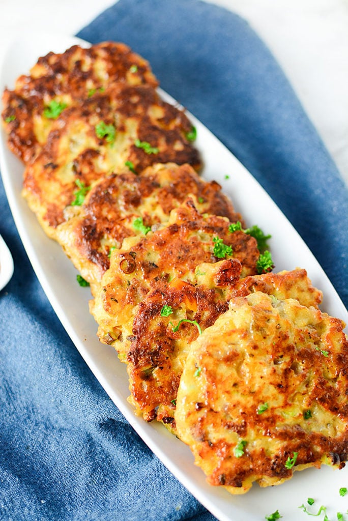 A fun photo of the potato and sausage cakes lined up on a white plate. They're perfect for serving for breakfast!