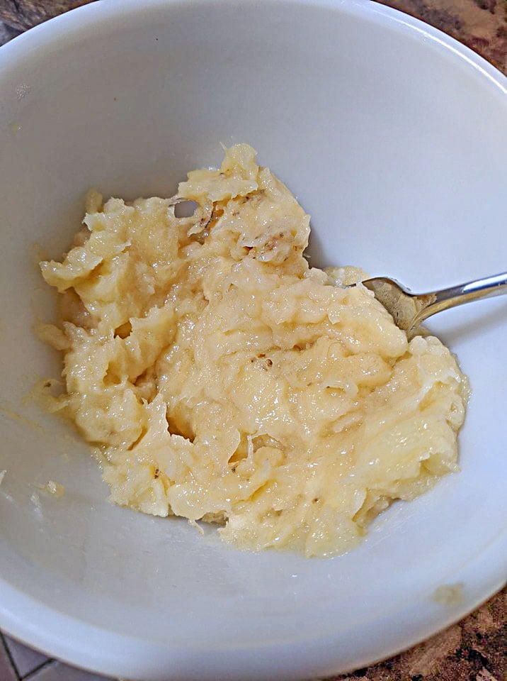 Mashed yellow bananas in a white bowl