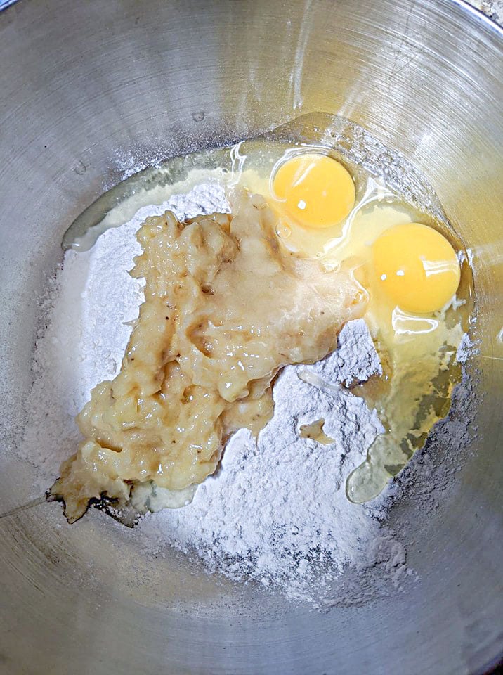 flour, mashed banana and eggs in a silver bowl