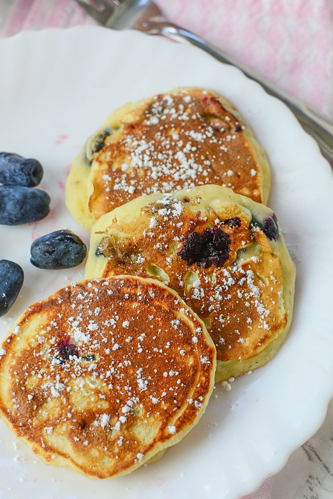 3 Honey berry pancakes sitting on a white plate.