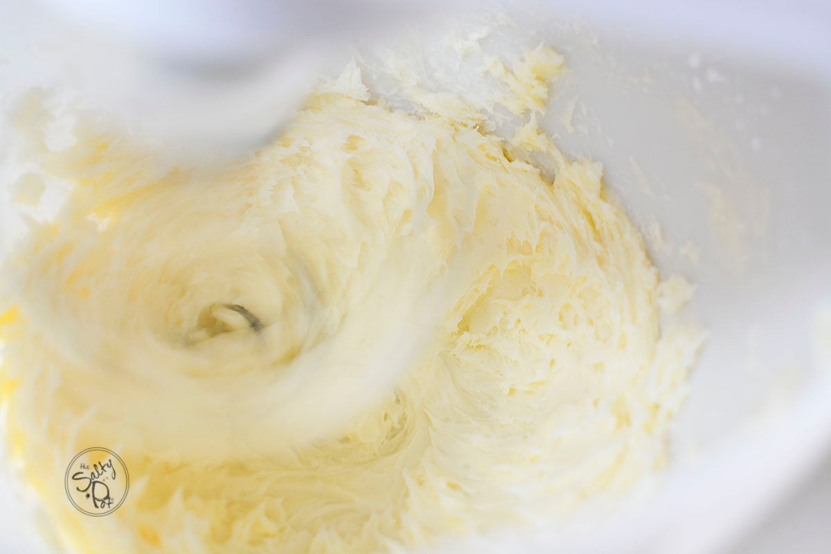 Butter being whipped in a stand mixer.