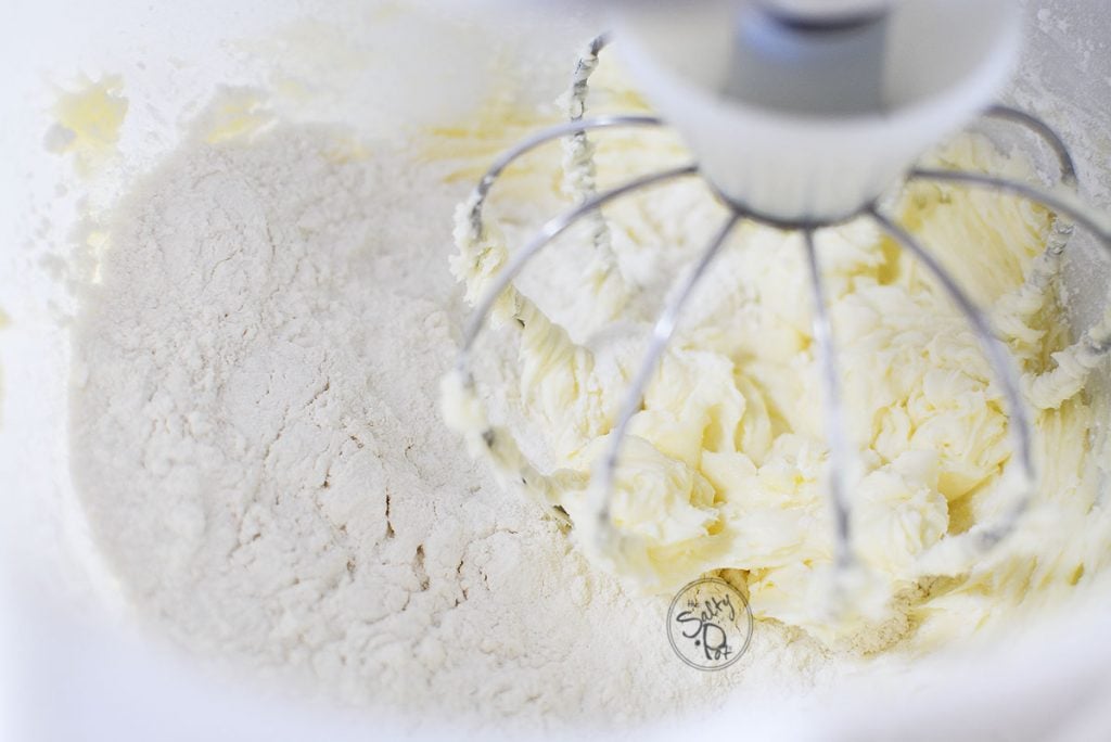 After adding the icing sugar to the butter and incorporating air, now the flour is added.