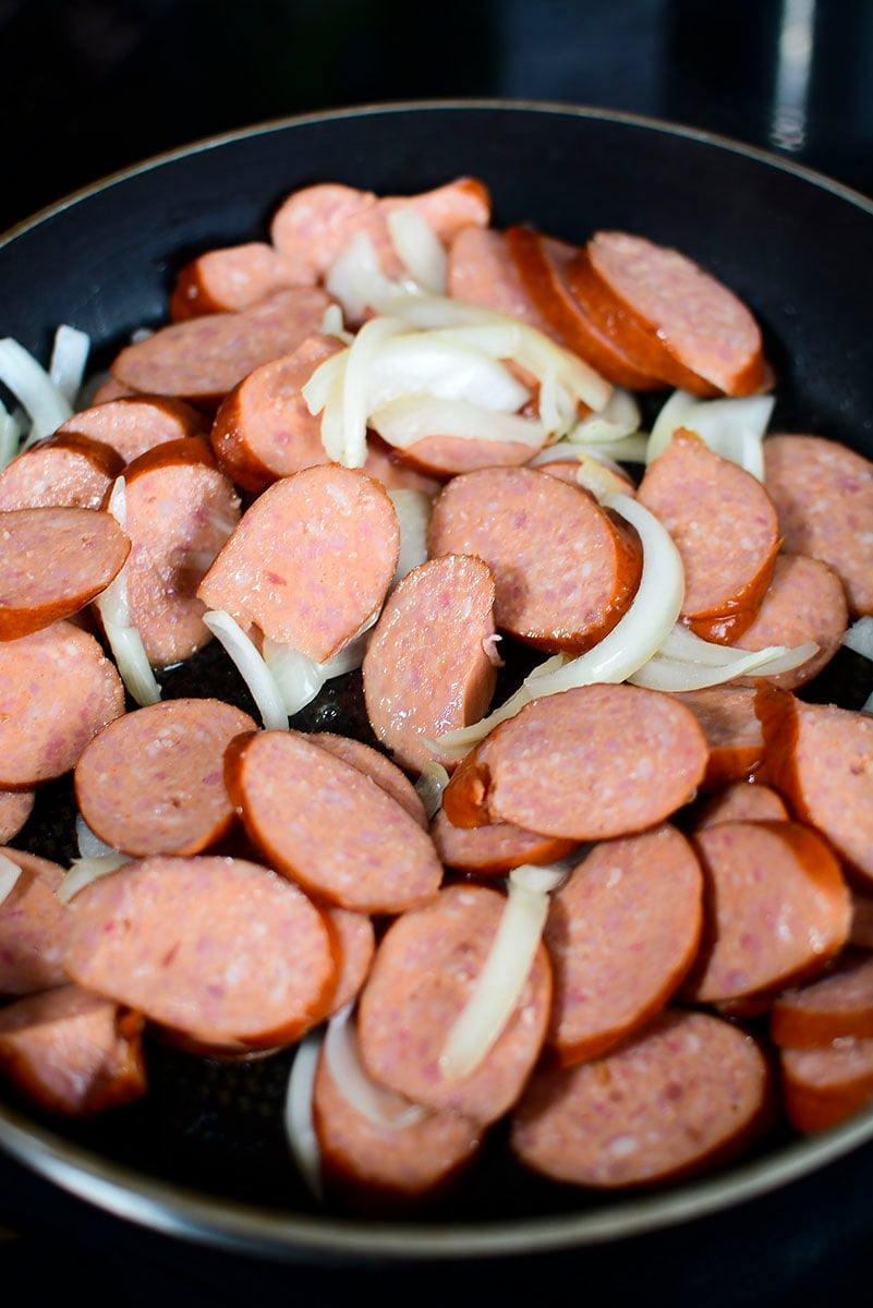 Sausage and onions in a pan.