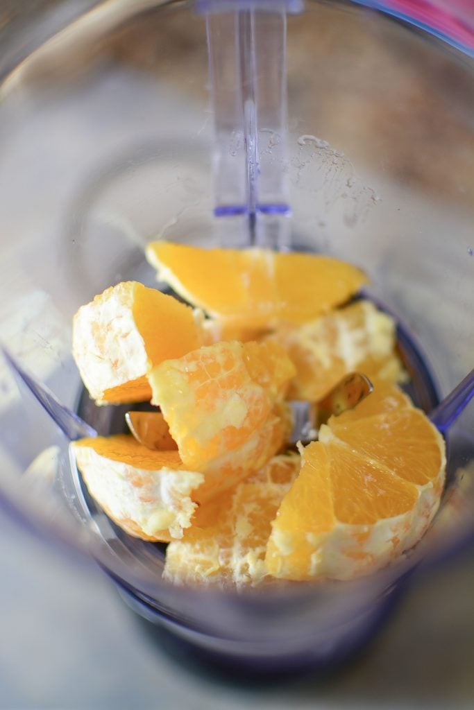 The orange cut up into sections and sitting in the blender, ready to become healthy gummies!