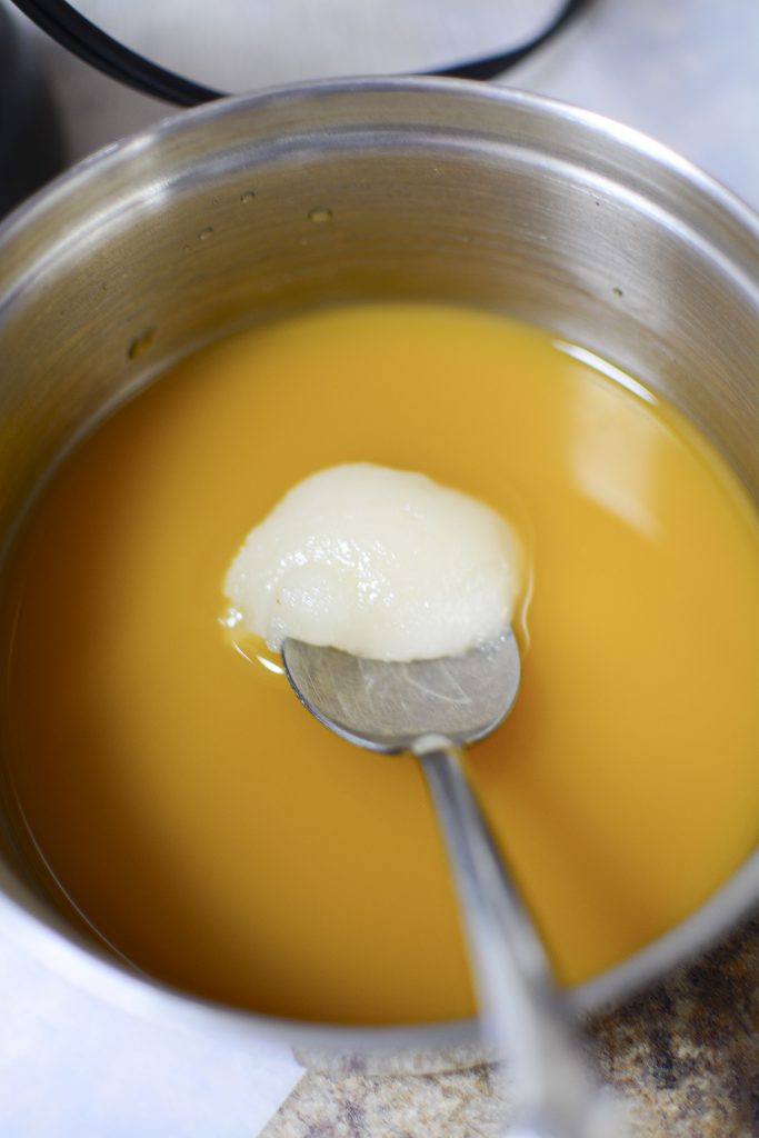 The honey being stirred into the mango orange juice blend