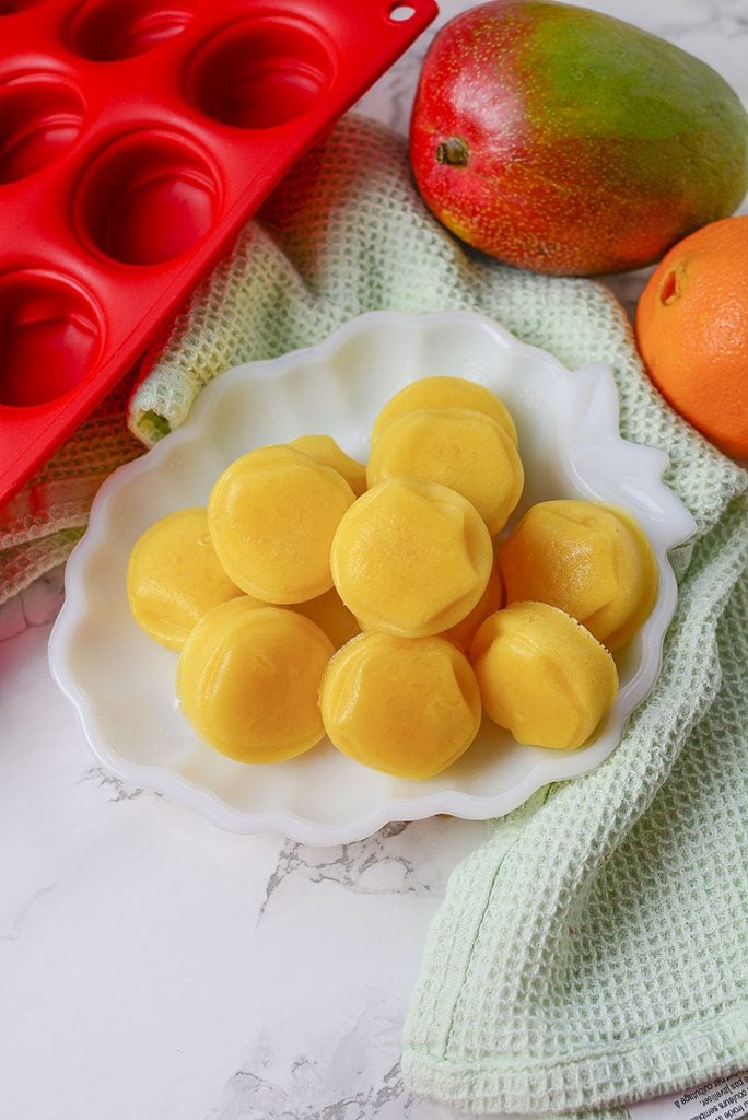 Mango orange gummy treats sitting in a white dish ready to be enjoyed!